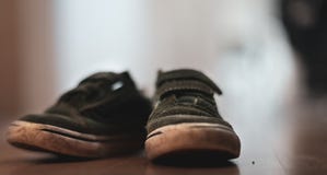 Παπούτσια ενός μικρά φορεμένα αγόρια πράσινα velcro σε ένα ξύλινο πάτωμα στοκ εικόνες Παπούτσια ενός μικρά φορεμένα αγόρια πράσινα velcro σε ένα ξύλινο πάτωμα στοκ εικόνες