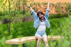 Πορτρέτο της όμορφης νέας γυναίκας brunette την μπλε περιστασιακή συνεδρίαση ύφους τζιν και την υπαίθρια άνοιξη, που χασμουριέται στοκ εικόνα Πορτρέτο της όμορφης νέας γυναίκας brunette την μπλε περιστασιακή συνεδρίαση ύφους τζιν και την υπαίθρια άνοιξη, που χασμουριέται στοκ εικόνα