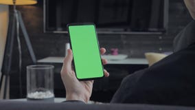 Πράσινη οθόνη - άτομο που κρατά ένα smartphone Πέρα από την όψη ώμων απόθεμα βίντεο Πράσινη οθόνη - άτομο που κρατά ένα smartphone Πέρα από την όψη ώμων απόθεμα βίντεο