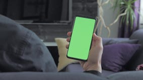 Πράσινη οθόνη - άτομο που κρατά ένα smartphone Πέρα από την όψη ώμων απόθεμα βίντεο Πράσινη οθόνη - άτομο που κρατά ένα smartphone Πέρα από την όψη ώμων απόθεμα βίντεο