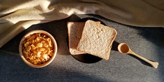 Πρόγευμα: ψωμί και δημητριακά για το πρωί στοκ εικόνα Πρόγευμα: ψωμί και δημητριακά για το πρωί στοκ εικόνα