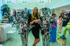 Дама toastmaster представляет для камеры между dansers в отражая сюитах стоковое фото Дама toastmaster представляет для камеры между dansers в отражая сюитах стоковое фото