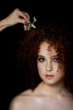 Девушка с сочными курчавыми красными волосами Чувствительный макияж с ложными ресницами в стиле куклы Визажист регулирует ее воло стоковые фотографии rf Девушка с сочными курчавыми красными волосами Чувствительный макияж с ложными ресницами в стиле куклы Визажист регулирует ее воло стоковые фотографии rf