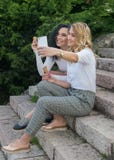 2 девушки принимают selfies и едят мороженое стоковое изображение 2 девушки принимают selfies и едят мороженое стоковое изображение