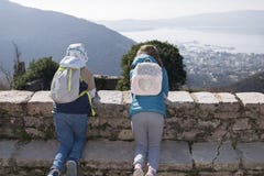 2 дет встают на колени на каменной стене в горном селе в предыдущей весне и смотрят вниз на заливе и городе, Gornja Lastva, стоковые изображения 2 дет встают на колени на каменной стене в горном селе в предыдущей весне и смотрят вниз на заливе и городе, Gornja Lastva, стоковые изображения