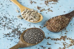 Деревянные ложки с семенами подсолнуха, chia и льняным семенем стоковое фото rf Деревянные ложки с семенами подсолнуха, chia и льняным семенем стоковое фото rf