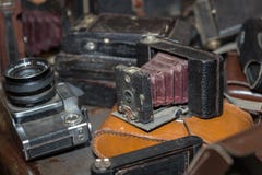 Античная складывая камера с мембранами в куче старых камер стоковая фотография Античная складывая камера с мембранами в куче старых камер стоковая фотография