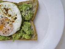 Аппетитное bruschetta с яйцом и авокадоом на плите стоковое изображение rf Аппетитное bruschetta с яйцом и авокадоом на плите стоковое изображение rf