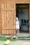 Босоногая девушка в стойках sundress лета во входе сарая стоковое изображение rf Босоногая девушка в стойках sundress лета во входе сарая стоковое изображение rf