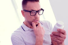 Бородатый зрелый человек с лицевыми морщинками чувствуя неуверенный о принимать витамины стоковое фото rf Бородатый зрелый человек с лицевыми морщинками чувствуя неуверенный о принимать витамины стоковое фото rf