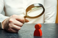 Бизнес-леди рассматривает диаграмму красного человека через лупу Анализ личных качеств работника стоковое фото rf Бизнес-леди рассматривает диаграмму красного человека через лупу Анализ личных качеств работника стоковое фото rf