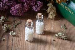 Бутылки гомеопатических таблеток с высушенными травами и medica materia стоковое фото Бутылки гомеопатических таблеток с высушенными травами и medica materia стоковое фото