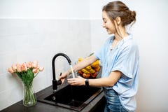 Вода из крана женщины заполняя на кухне стоковое изображение rf Вода из крана женщины заполняя на кухне стоковое изображение rf