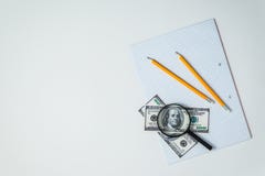 Взгляд сверху или flatlay чистого листа тетради школы с карандашем и долларами и лупой стоковые изображения rf Взгляд сверху или flatlay чистого листа тетради школы с карандашем и долларами и лупой стоковые изображения rf