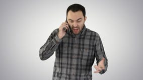 Говорить человека сердитый на телефоне и идти на предпосылку градиента стоковое фото Говорить человека сердитый на телефоне и идти на предпосылку градиента стоковое фото