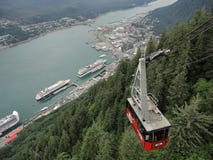 Горная цепь с лесами и потоком Сочный воздержательный тропический лес в Аляске с облаками и солнцем стоковые изображения rf Горная цепь с лесами и потоком Сочный воздержательный тропический лес в Аляске с облаками и солнцем стоковые изображения rf