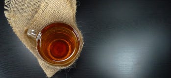 Горячие стекло чашки чая на зимний день с мешковиной/гессенский на черном времени чая предпосылки! стоковые фото Горячие стекло чашки чая на зимний день с мешковиной/гессенский на черном времени чая предпосылки! стоковые фото