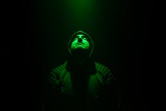 Гай нося черного прыгуна в темной комнате Зеленый свет на стороне стоковые фотографии rf Гай нося черного прыгуна в темной комнате Зеленый свет на стороне стоковые фотографии rf