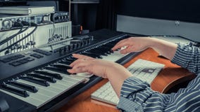 Женский музыкант играя синтезатор клавиатуры midi в студии звукозаписи, фокусе на руках Запев игр оружий женщины музыки или новое стоковое фото rf Женский музыкант играя синтезатор клавиатуры midi в студии звукозаписи, фокусе на руках Запев игр оружий женщины музыки или новое стоковое фото rf