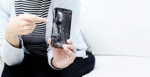 Женщины нося голубую рубашку держа сломленный мобильный телефон стоковые изображения Женщины нося голубую рубашку держа сломленный мобильный телефон стоковые изображения