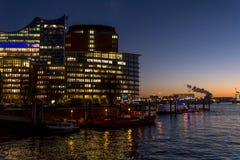 Загоренное здание вечером в квартале HafenCity, Гамбурге, Германии стоковые изображения rf Загоренное здание вечером в квартале HafenCity, Гамбурге, Германии стоковые изображения rf