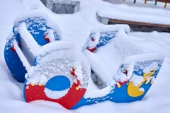 Закройте вверх шлюпки покрытой снегом форменное колебание seesaw шатается в парке игры детей во время холодного сезона зимы стоковые изображения Закройте вверх шлюпки покрытой снегом форменное колебание seesaw шатается в парке игры детей во время холодного сезона зимы стоковые изображения