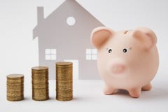 Закройте вверх розовых piggy стогов банка денег золотых монеток на белой предпосылке стены с домом Накопление денег стоковое изображение Закройте вверх розовых piggy стогов банка денег золотых монеток на белой предпосылке стены с домом Накопление денег стоковое изображение