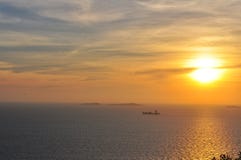 Заход солнца над морем со шлюпкой на заднем плане стоковое изображение Заход солнца над морем со шлюпкой на заднем плане стоковое изображение
