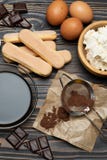 Ингредиенты для варить тирамису - печенья, mascarpone, сливк, сахар, какао, кофе и яйцо печенья Savoiardi стоковое фото rf Ингредиенты для варить тирамису - печенья, mascarpone, сливк, сахар, какао, кофе и яйцо печенья Savoiardi стоковое фото rf
