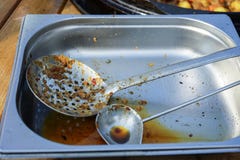 Используемая ложь ковша и шумовки на подносе металла стоковые фотографии rf Используемая ложь ковша и шумовки на подносе металла стоковые фотографии rf