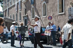 Итальянский полицейский жестикулируя, аркада Venezia, Рим, Италия стоковая фотография Итальянский полицейский жестикулируя, аркада Venezia, Рим, Италия стоковая фотография