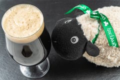 Концепция дня ` s St. Patrick Пинта ирландского стаута и ирландских овец стоковое изображение Концепция дня ` s St. Patrick Пинта ирландского стаута и ирландских овец стоковое изображение