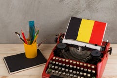 Концепция политических, новостей и образования - красная машинка, флаг Бельгии, тетрадь и канцелярские принадлежности стоковые фото Концепция политических, новостей и образования - красная машинка, флаг Бельгии, тетрадь и канцелярские принадлежности стоковые фото