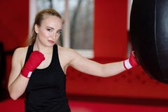 Красивый sporty бокс женщины с красной грушей на спортзале стоковые фотографии rf Красивый sporty бокс женщины с красной грушей на спортзале стоковые фотографии rf