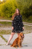 Красивый и молодая женщина в платье с собакой в лесе лета стоковая фотография rf Красивый и молодая женщина в платье с собакой в лесе лета стоковая фотография rf