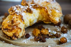 Круассаны миндалины с напудренным сахаром и гайками на деревянной доске стоковые изображения Круассаны миндалины с напудренным сахаром и гайками на деревянной доске стоковые изображения