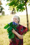 80 - летняя женщина с букетом цветков в ее руках стоковое изображение 80 - летняя женщина с букетом цветков в ее руках стоковое изображение