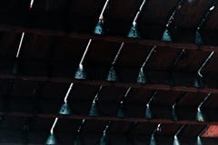 Лучи света светя через отказы между темными деревянными floorboards стоковое изображение rf Лучи света светя через отказы между темными деревянными floorboards стоковое изображение rf