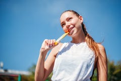 Молодая женщина атлетических спорт держит шоколадный батончик зуба стоковые изображения Молодая женщина атлетических спорт держит шоколадный батончик зуба стоковые изображения