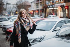 Молодая счастливая усмехаясь женщина в черных пальто и шарфе идя вокруг города Ожидание ее парня Ждать встречать стоковая фотография rf Молодая счастливая усмехаясь женщина в черных пальто и шарфе идя вокруг города Ожидание ее парня Ждать встречать стоковая фотография rf