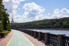 Москва/Россия - 2-ое августа 2013: Обваловка реки Москвы За деревьями строя государственный университет Москвы стоковая фотография Москва/Россия - 2-ое августа 2013: Обваловка реки Москвы За деревьями строя государственный университет Москвы стоковая фотография