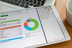 Москва/Россия - 2-ое марта 2019: Белое ipad лежит на клавиатуре macbook, на экране диаграммы Рядом чашка стоковое изображение rf Москва/Россия - 2-ое марта 2019: Белое ipad лежит на клавиатуре macbook, на экране диаграммы Рядом чашка стоковое изображение rf