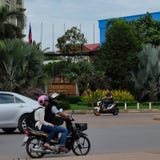 Мотороллеры и автомобили управляют около гостиницы, Юго-Восточной Азии стоковая фотография rf Мотороллеры и автомобили управляют около гостиницы, Юго-Восточной Азии стоковая фотография rf