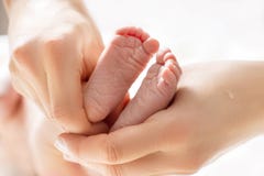 Мама массажирует ноги newborn младенца Ноги младенца в руках мати стоковая фотография rf Мама массажирует ноги newborn младенца Ноги младенца в руках мати стоковая фотография rf