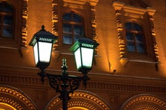 Накаляя горящий фонарик на штендере утюга на конце предпосылки кирпичной стены старинного здания желтом вверх по историческому це стоковое фото Накаляя горящий фонарик на штендере утюга на конце предпосылки кирпичной стены старинного здания желтом вверх по историческому це стоковое фото