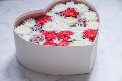 Подарочная коробка с сердцем сформировала цветки на серой мраморной предпосылке стоковая фотография rf Подарочная коробка с сердцем сформировала цветки на серой мраморной предпосылке стоковая фотография rf