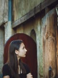 Портрет довольно темн-с волосами девушки на предпосылке старого здания стоковая фотография Портрет довольно темн-с волосами девушки на предпосылке старого здания стоковая фотография