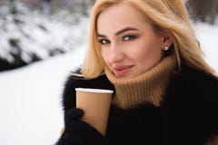 Портрет европейского кофе модной женщины стиля выпивая в парке зимы стоковое изображение Портрет европейского кофе модной женщины стиля выпивая в парке зимы стоковое изображение
