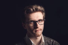Портрет молодого случайного человека со стеклами усмехаясь перед камерой Молодой красивый человек в рубашке и стеклах военно-морс стоковая фотография rf Портрет молодого случайного человека со стеклами усмехаясь перед камерой Молодой красивый человек в рубашке и стеклах военно-морс стоковая фотография rf