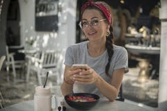 Портрет милой девушки с косичкой и bandana, имеющ остатки в кафе лета стоковые изображения rf Портрет милой девушки с косичкой и bandana, имеющ остатки в кафе лета стоковые изображения rf